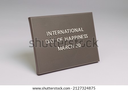 international day of happiness 20 march lettering on gray chalkboard, white background