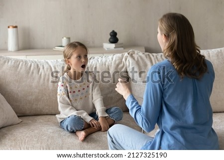 Singing teacher training student girl kid at home. Speech therapist teaching child to do voice, speaking exercises, helping to cope stutter, bad pronunciation, communication problems Royalty-Free Stock Photo #2127325190