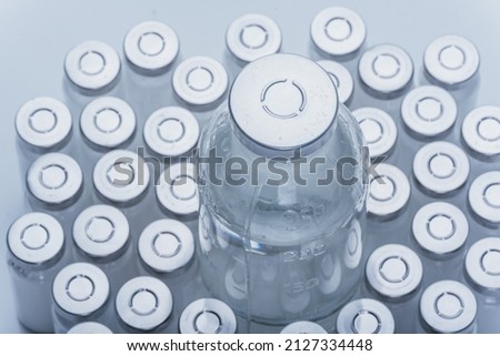 Glass medical ampoule vial for injection. Medicine is dry white drug penicillin powder or liquid with of aqueous solution in ampulla. Close up. Bottles ampule with aluminum cap on backgrounds gray. Royalty-Free Stock Photo #2127334448