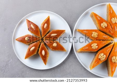Plates with Azerbaijani national pastries for Novruz - Ganja and Baku style pakhlava and shekerbura on light grey background for Novruz celebration, spring equinox and new year celebration in March.