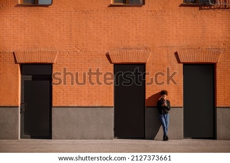 A female figure of a background of brick wall