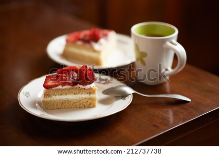 sponge cake decorated with strawberries cup of coffee