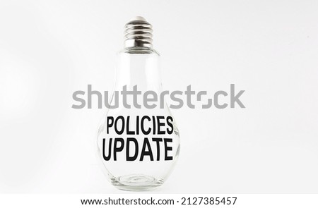 Text POLICIES UPDATE on bulb on white background. Business concept