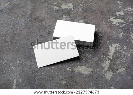 Photo of blank business cards on concrete background. Mock-up for branding identity for designers.