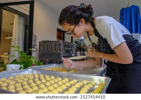 Asian woman baking cake at home.