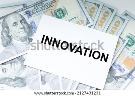 The text INNOVATION on a business card against the background of paper money dollars