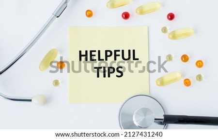 a card with Helpful Tips on a white background next to scattered tablets and lies a stethoscope
