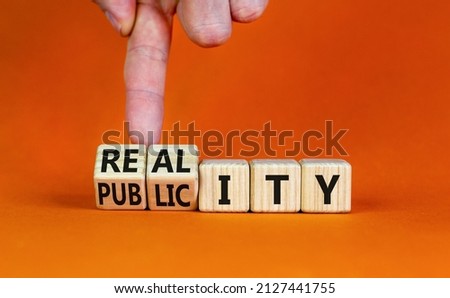Reality or publicity symbol. Businessman turns wooden cubes and changes the word Publicity to Reality. Beautiful orange table orange background. Business reality or publicity concept. Copy space.