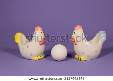 two chickens and an egg on a purple background