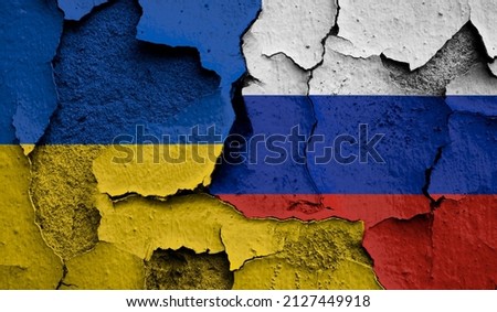 Flag of Ukraine and  Russia on old grunge wall in background  Royalty-Free Stock Photo #2127449918