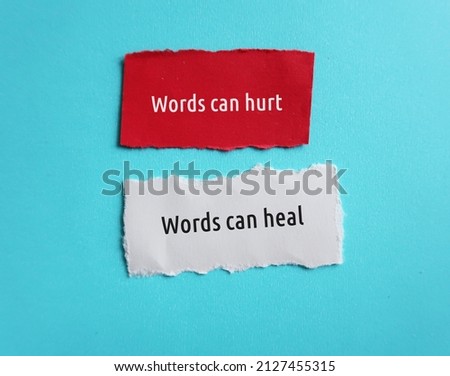 Torn paper on blue background with text Words can hurt , Words can heal - to remind language have power to harm or heal - word choice matters most so choose wisely Royalty-Free Stock Photo #2127455315