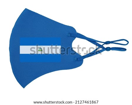 Blue cotton reusable cloth protective mask looks as flag of Republic of Nicaragua isolated on white background. 
