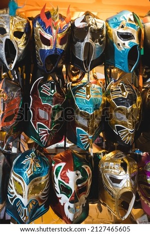 Various colorful wrestling mask hangs from a shop apparel.