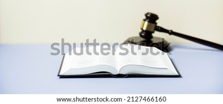 Law concept - law book with a wooden judges gavel on table in a courtroom or law enforcement office. Copy space for text. Banner 