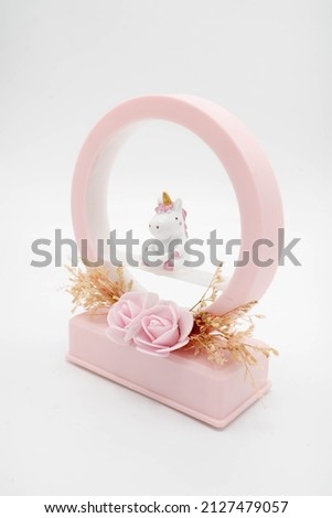 A pink music box with a cute rhinoceros doll in the middle.