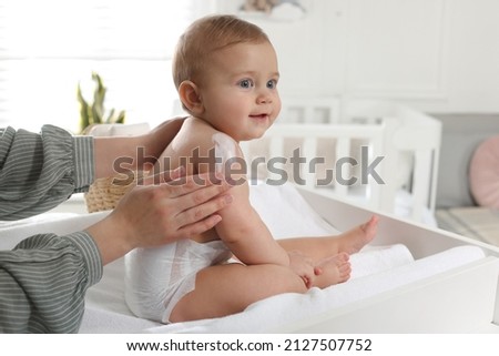 Mother applying body cream on her little baby at home, closeup Royalty-Free Stock Photo #2127507752