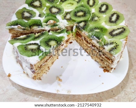 cut cake with kiwi and ice cream on a plate close up