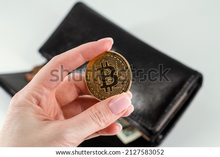 Gold bitcoin holding in hand putting into the wallet