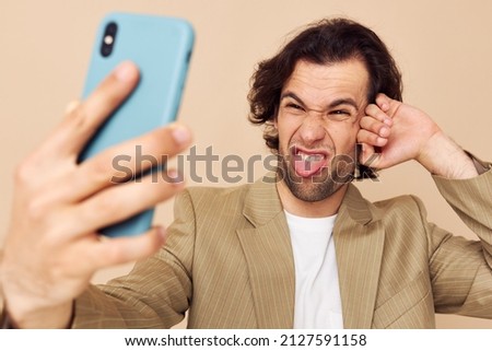 Attractive man in a suit posing emotions looking at the phone isolated background