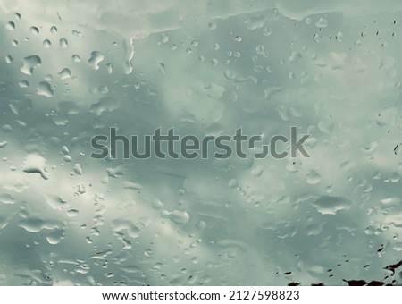 raindrops on a pane against the gray rainy sky