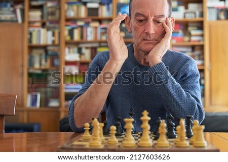 Alzheimer and dementia prevention metaphor. Brain training with senior citizen playing chess Royalty-Free Stock Photo #2127603626