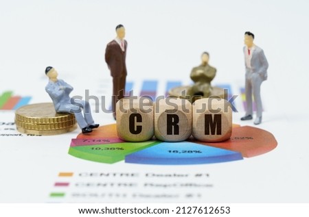 Business and finance concept. On financial reports with diagrams, figures of businessmen and wooden cubes with the inscription - CRM
