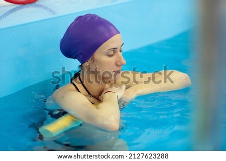 A young girl is engaged in aqua yoga in the pool. Swimming for pregnant women. Health concepts Royalty-Free Stock Photo #2127623288