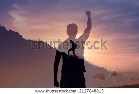 People conquering adversity, strong young motivated man climbing up a mountain setting goal to reach the top.  Royalty-Free Stock Photo #2127648815