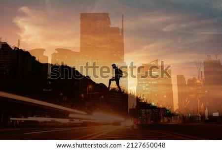 People in the city conquering adversity, strong young motivated man climbing up a mountain setting goal to reach the top. Never give up concept  Royalty-Free Stock Photo #2127650048