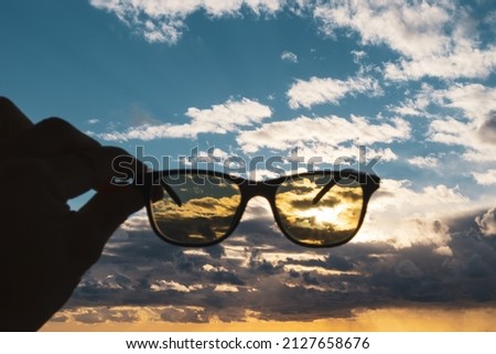 Sunglasses hand sky clouds holding sun glasses dark frame idea view depart yellow black look fashion Royalty-Free Stock Photo #2127658676
