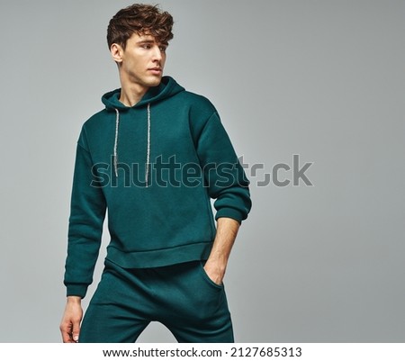 Handsome man wear of green set of track suit isolated on grayl background Royalty-Free Stock Photo #2127685313