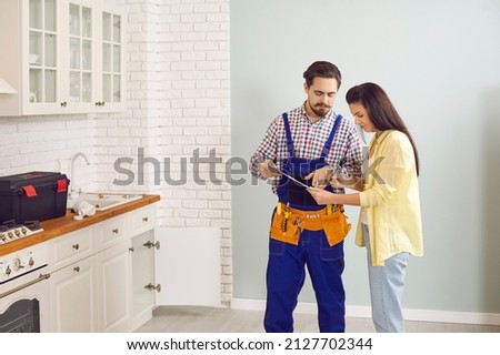 Male plumber or mechanic talk speak with female client at home. Man mechanic or repairman consult woman customer about plumbing water system. Maintenance and household service. Royalty-Free Stock Photo #2127702344
