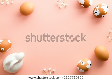 Easter color background with Easter eggs decorated flowers and Easter bunny. Flat lay, top view, copy space.