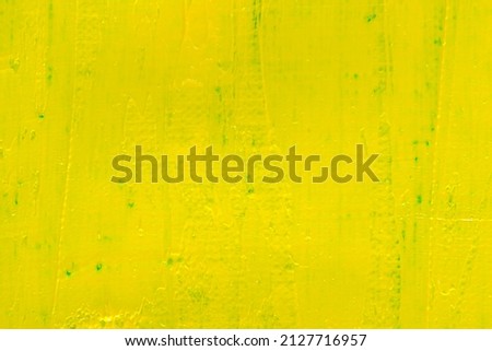 abstract bright colored background: yellow paint on blue fabric close 