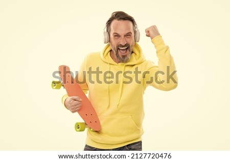 happy man listen music in headphones hold penny skateboard isolated on white, skateboard hobby.