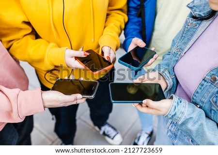 Group of millennial people holding smartphone outdoors - Teenage multiracial students looking using mobile phone app Royalty-Free Stock Photo #2127723659