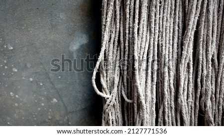 isolated gray cement wall with a mop made of nylon rope suitable for a quote background