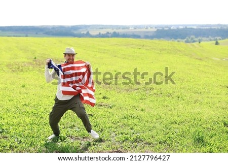 Man waving American flag standing in farm agricultural field , holidays, patriotism, pride, freedom, political parties, immigrant