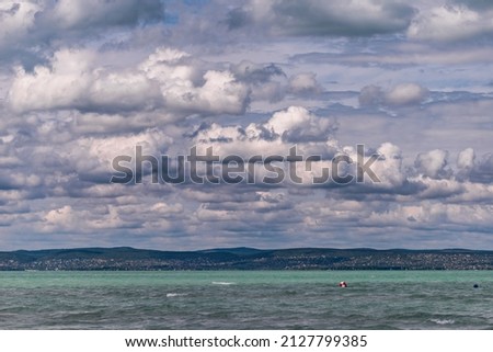 Photo of Balaton Lake in Siofok, Hungary. Dramatic Cloudy sky and blue, tourquise water.