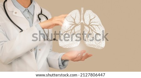Female doctor holding virtual Lungs in hand. Handrawn human organ, copy space on right side, beige color. Healthcare hospital service concept stock photo Royalty-Free Stock Photo #2127806447