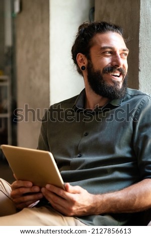 Portrait of successful handsome business man using digital tablet in office