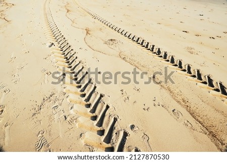 Wheel tracks of the tractor on a tropical sandy beach with a sunny