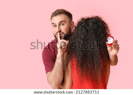 Young man going to make proposal to his girlfriend on color background