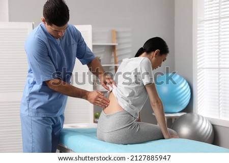 Orthopedist examining woman's back in clinic. Scoliosis treatment Royalty-Free Stock Photo #2127885947