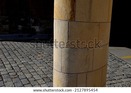 sandstone lookout column made of sandstone blocks in the shape of a cylinder or ellipse. standing on a sidewalk of granite cubes. clean stonemason's work Royalty-Free Stock Photo #2127895454