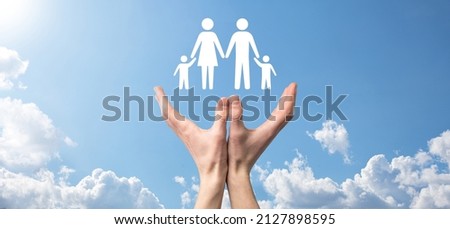 Hand on sky background holds family icon.Healthcare and life insurance concept.Father, mother, daughter and son