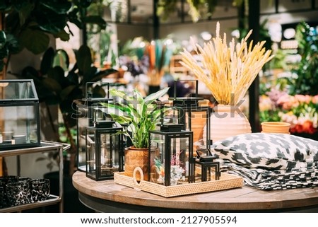 View of assortment of decor for interior shop in store of shopping center. Home accessories and household products for living room in store of shopping centre. View of decorative lantern on table Royalty-Free Stock Photo #2127905594