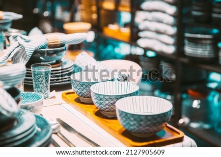 View of assortment of decor for interior shop in store of shopping center. Home accessories and household products for dining room in store of shopping centre. View of beautiful dinnerware on table Royalty-Free Stock Photo #2127905609