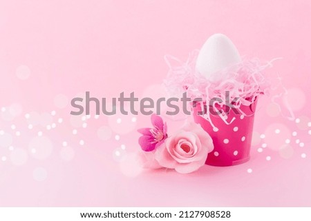 Easter background.Easter egg in bucket and flowers. Postcard with space for text in pink, toned