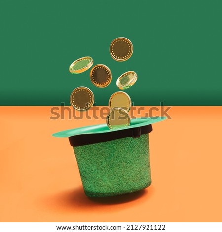 Minimal abstract magic treasure concept. Green glitter hat with golden coins levieting out of it. Green pastel and orange terracotta background.